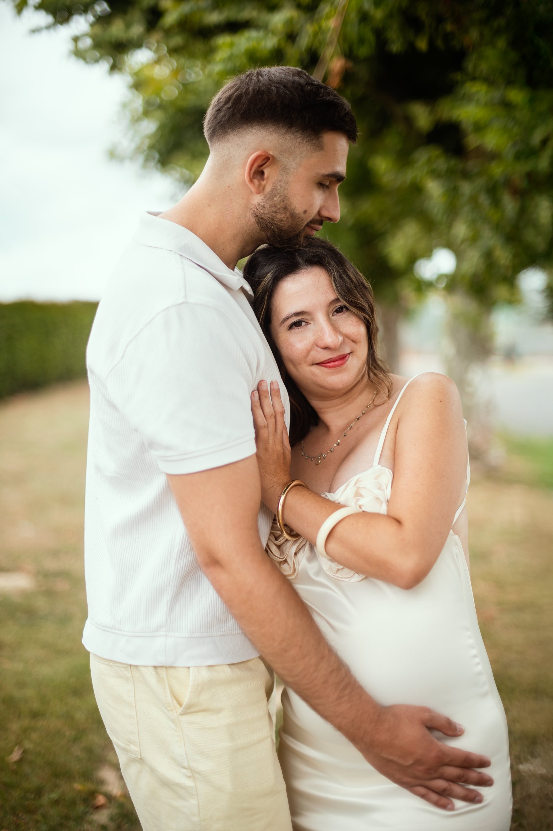 Couple enlacé, main sur le ventre arrondi