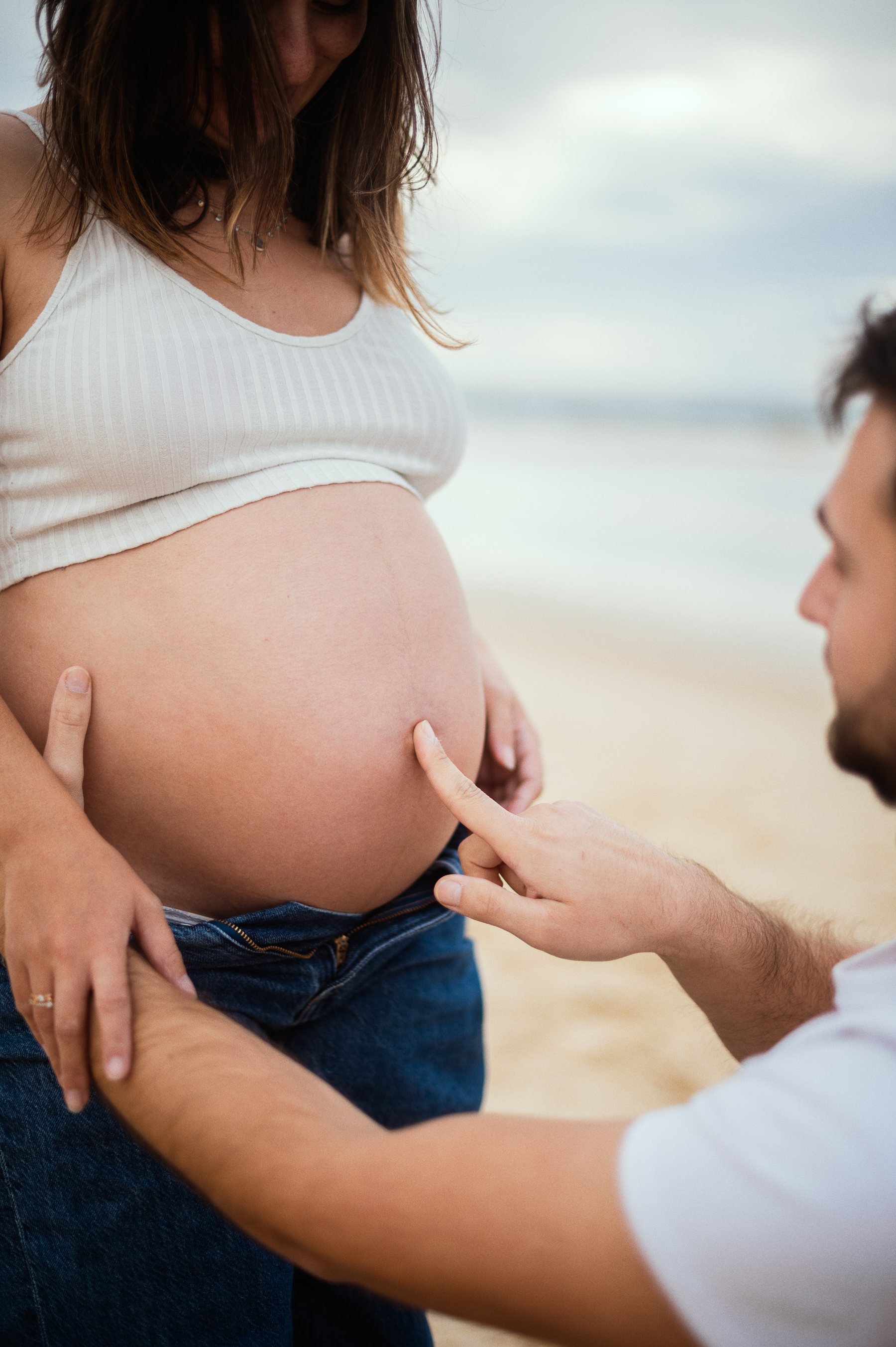 Mains du futur papa posées sur le ventre