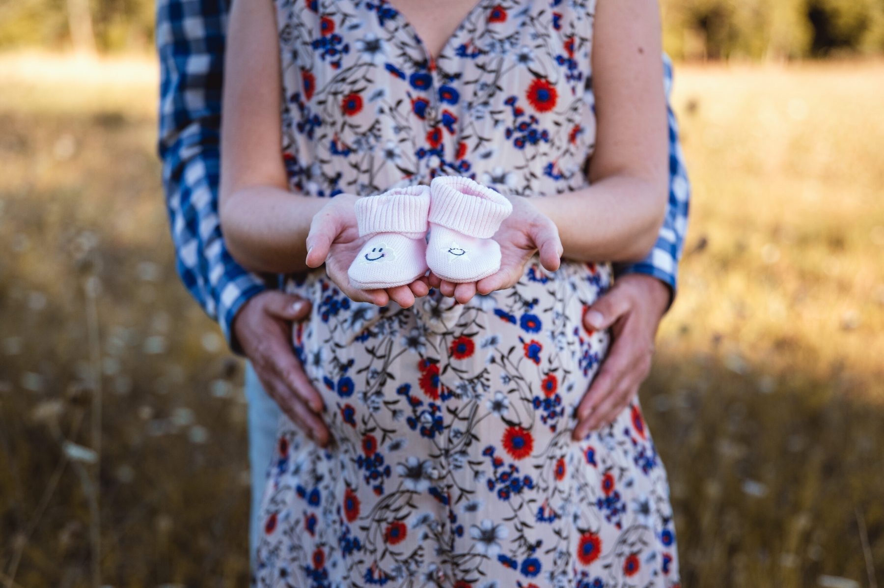 Femme enceinte, mains posées sur le ventre, lumière naturelle