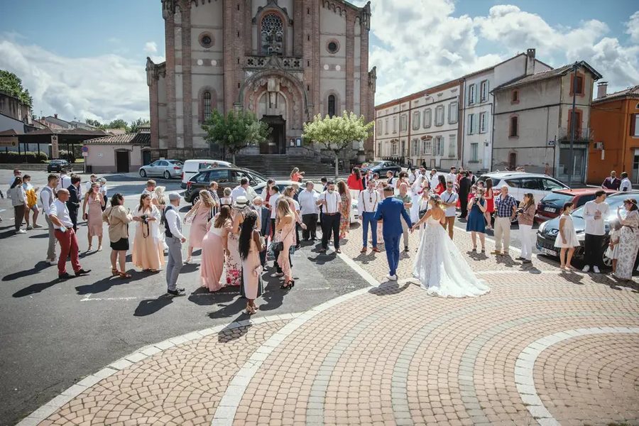 Cortège de mariage traversant une place, émotion